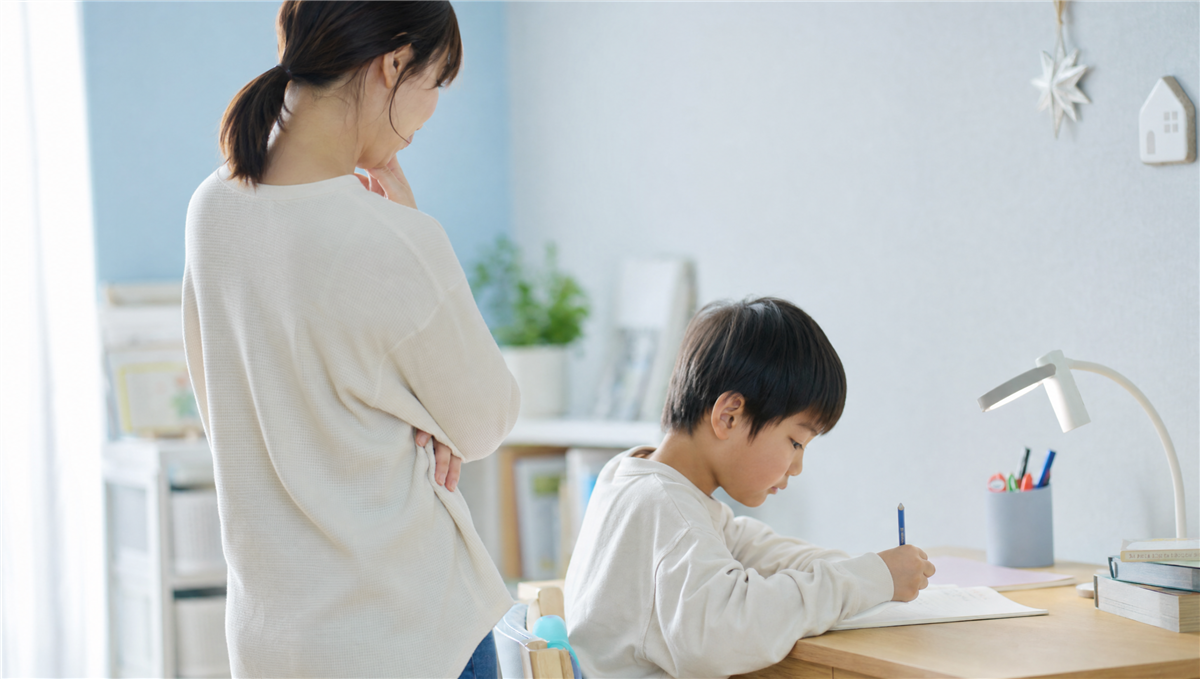 勉強を始める子どもを見守る母親